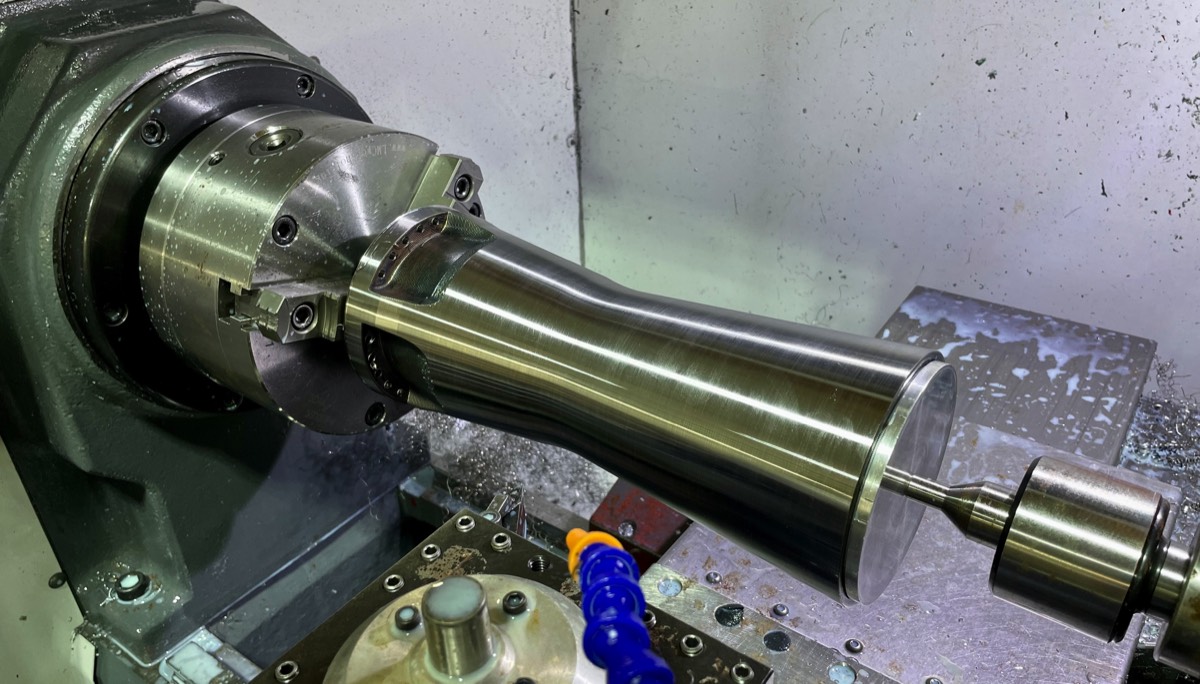 Robotic metal 3D printed part being precision finished on a lathe at Hooper Machine & Design